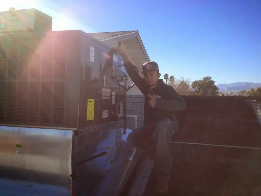 HVAC technician performing Heat Pump Repair on a rooftop unit in Moore
